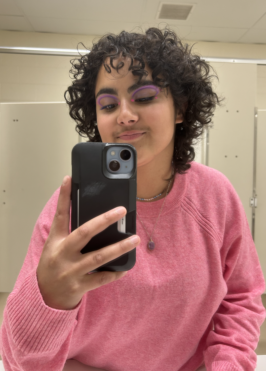 person with curly hair and graphic eyeliner