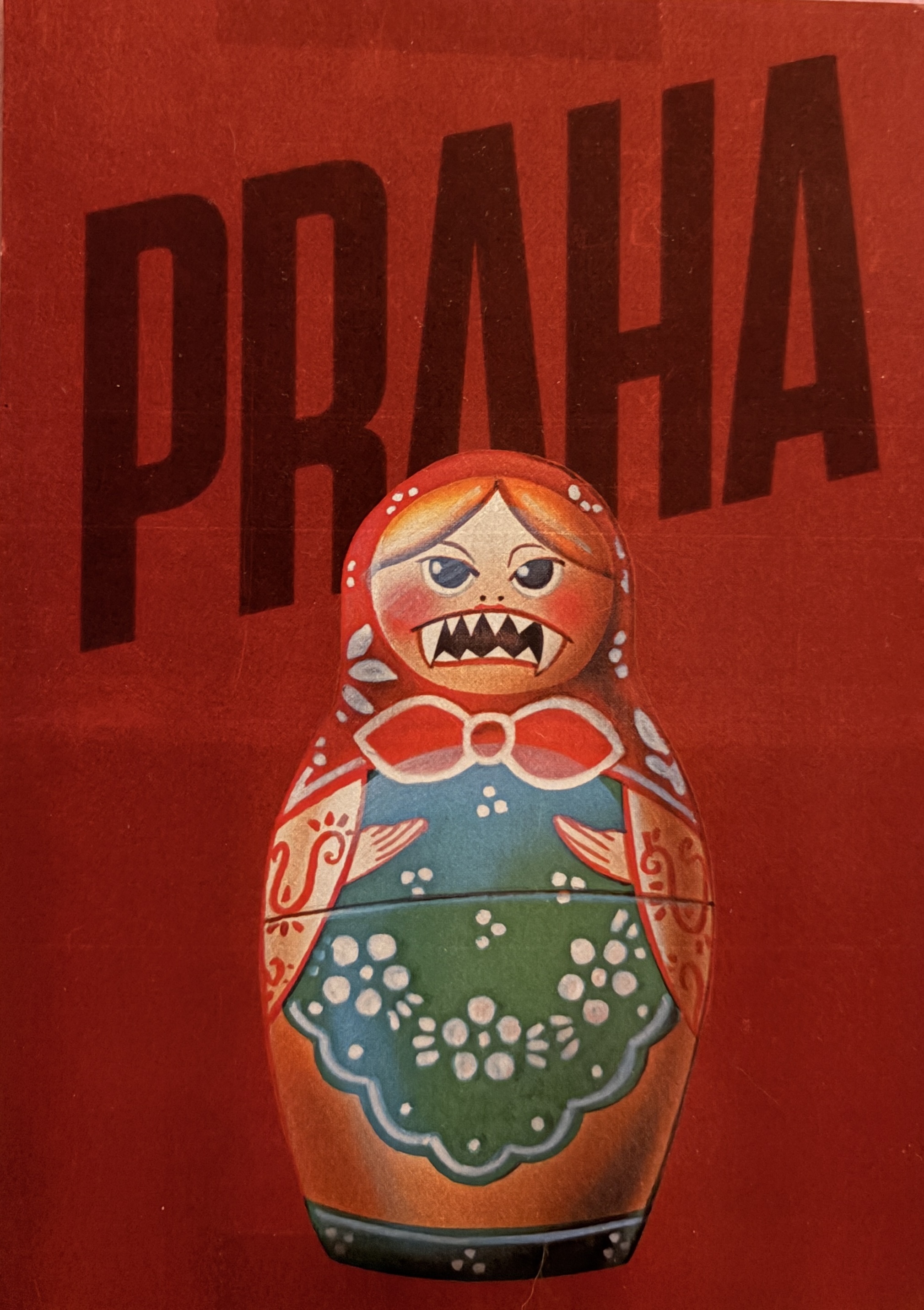 A red background behind a traditional Russian nesting doll with sharp teeth. Behind the nesting doll is the phrase 'Praha' in capital letters.