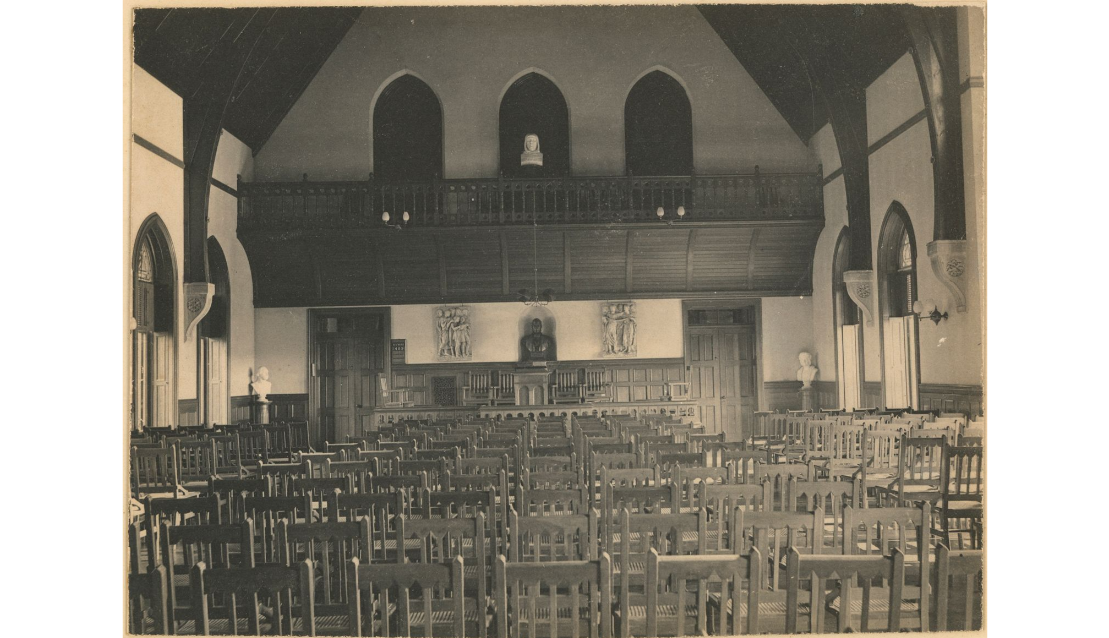 Interior view of the Chapel in Taylor Hall. The room is filled with chairs and decorated with several statues. The photograph was a part of the Sesqui-centennial Exposition of 1926.